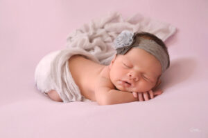 Newborn-baby-girl-posing-with-grey-headband