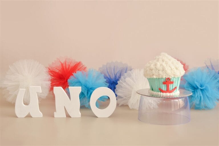 Cake smash setup with ONE letters, blue, red and white decorations to celebrate first birthday with a cake smash photoshoot in Kingston upon Thames.
