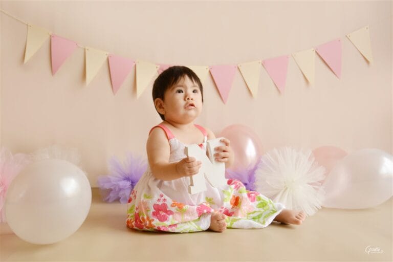 Cake smash setup with pink, cream and lilac decorations for a first birthday session in London.